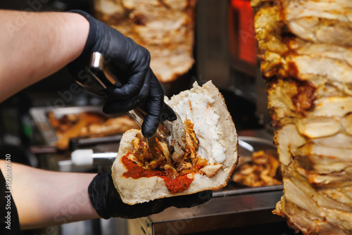 Chef Hands in Black Gloves Preparing Doner Kebab Sandwich with Sauces