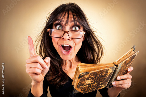 Emotionale Frau mit antikem Buch und Geistesblitz