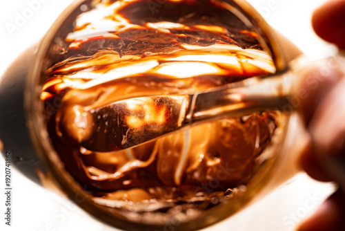 Closeup of the inside of a nearly empty jar of hazelnut spread with a silver butter knife inside