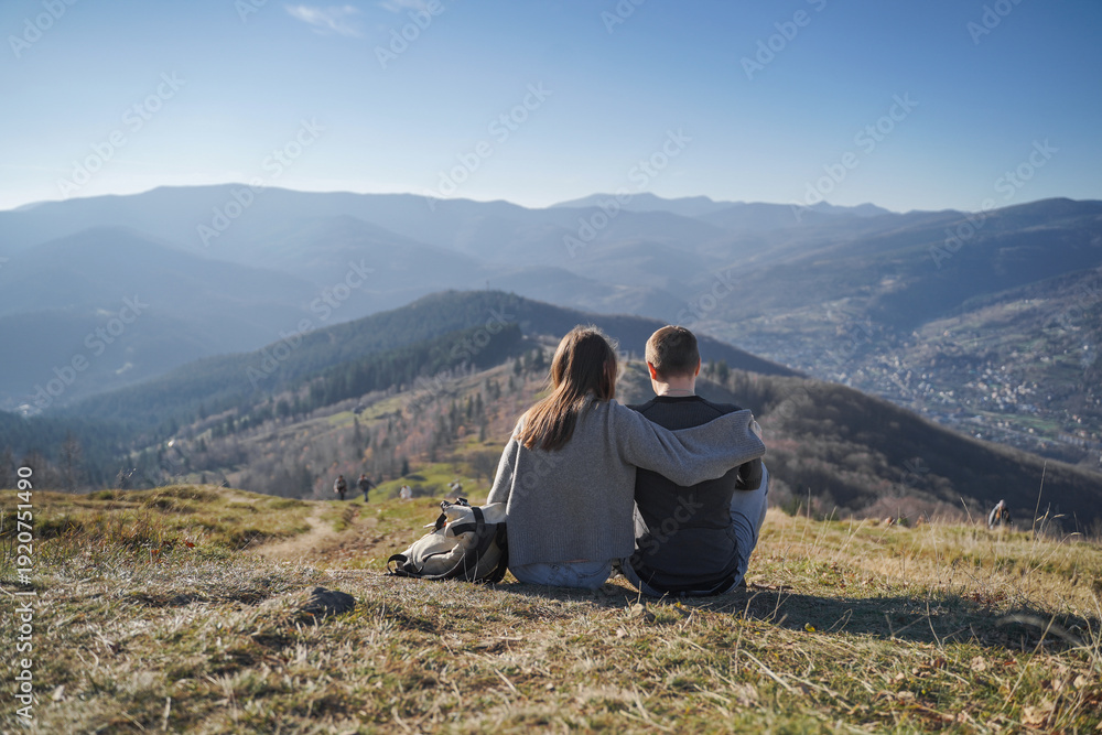 Fototapeta premium Couple Sitting on Mountain Hill Enjoying View