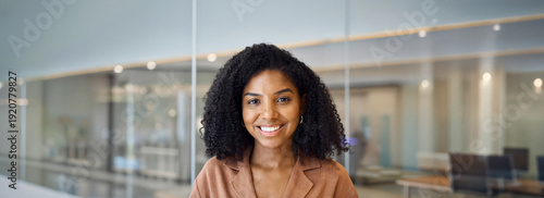 Foto Happy confident young African American business woman, entrepreneur or employee standing in office