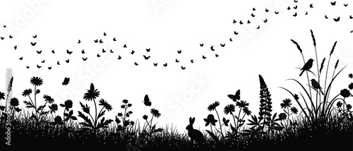 Silhouette of birds flying over grassy field at sunset with plants swaying gently in the breeze freely