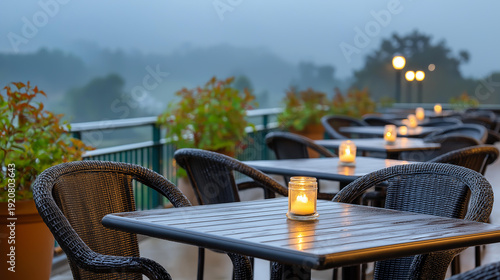 Wide outdoor cafe terrace at dawn mist rising from the ground single lit candle on each table chairs still upturned moody opening hour atmosphere atmospheric hospitality