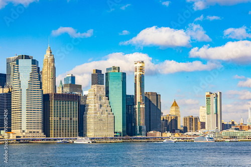 Panoramic view of Lower Manhattan skyline in New York City with historic 70 Pine Street building and modern skyscrapers along East River waterfront
