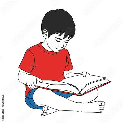 Young boy sitting cross-legged reading a book with focus and concentration.