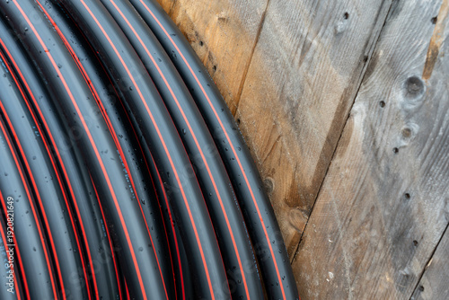 Fényképezés Close-up of heavy-duty black industrial tubing with red lines and water droplets