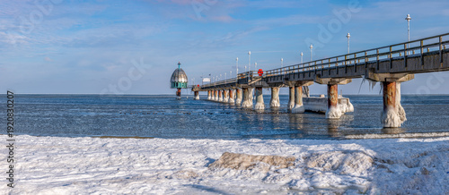 Zinnowitz – Seebrücke an der zugefrorenen Ostsee auf Usedom, Eisskulpturen am Strand bei Sonnenaufgang im Winter, seltenes Naturschauspiel