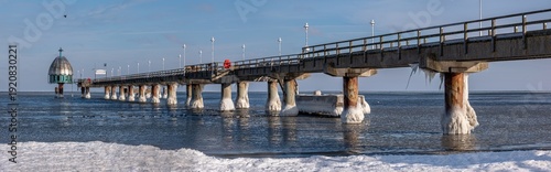 Zinnowitz – Seebrücke an der zugefrorenen Ostsee auf Usedom, Eisskulpturen am Strand bei Sonnenaufgang im Winter, seltenes Naturschauspiel