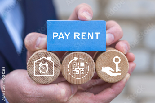 Foto Business person holding blocks with icons sees the text PAY RENT