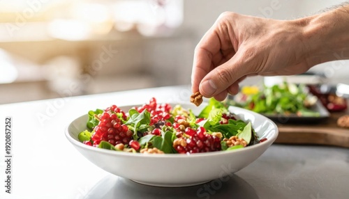 Wallpaper Mural Hand adding walnuts to a vibrant salad with fresh greens pomegranate seeds and natural light in a modern kitchen setting Torontodigital.ca
