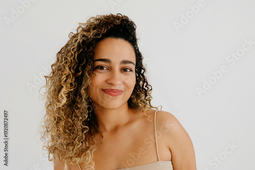 Smiling curly haired woman looking at camera