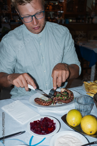 A man eating octopus in the taverna