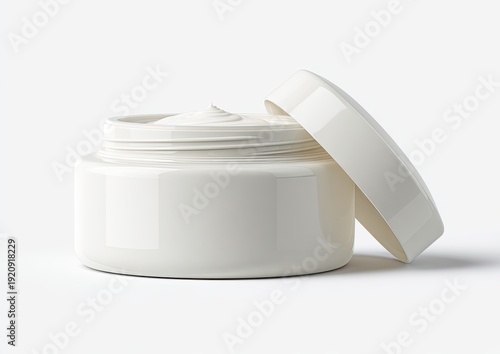 Jar of cream, open, with smooth swirl. Lid next to it, set against white background