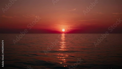 Vivid sunset paints the ocean horizon with fiery hues and shimmering golden light