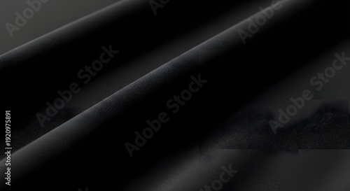 Elegant black fabric texture with folds and shadows for background use