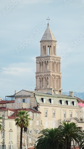 Saint Domnius bell tower rising above historic buildings and palm trees. Split, Croatia