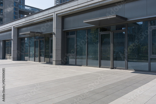 Tableau sur toile Modern commercial street with vacant glass-fronted storefronts and clean pavemen