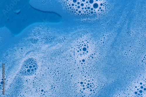 Close-up of blue soapy water with bubbles creating a swirling textured pattern background