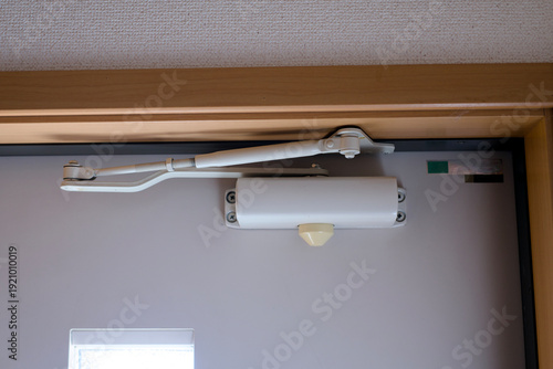 Vászonkép Automatic white hydraulic door closer mounted on door
