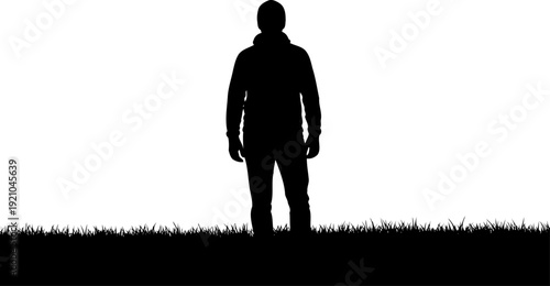 Man standing alone in a grassy field silhouette