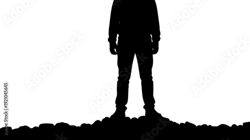 Man standing on rocky ground silhouette view