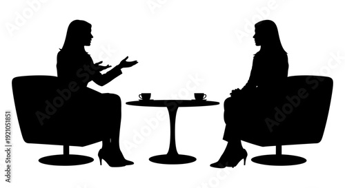 two female silhouettes intently discussing at a coffee table portraying a business meeting job interview or coaching session concept.