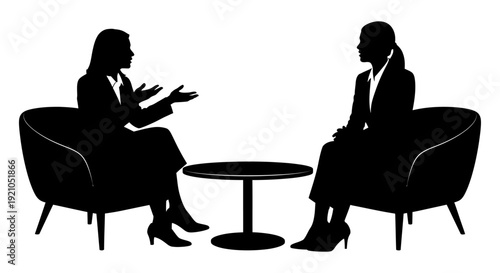 two professional women in silhouette having a business discussion or interview seated across a table illustrating effective communication.