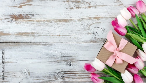 springtime pink tulips on white rustic wooden boards for Mothers Day or Easter holiday concept