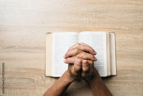 Wallpaper Mural Old man hands clasped prayer with Holy Bible for Christian faith, spirituality, worship, devotion, hope, and religious belief, prayer time in church, trust in God, and spiritual guidance. Torontodigital.ca