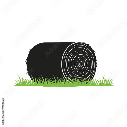 A black hay bale rests in a field of vibrant green grass
