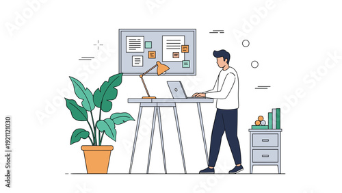 Young man working at a standing desk with a laptop and a creative mood board in a clean, organized, and modern home office space.