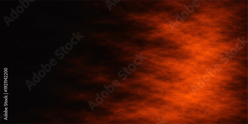 Dramatic fire flames dance against an abstract dark sky filled with orange sunset clouds and a red storm light for a beautiful nature landscape background