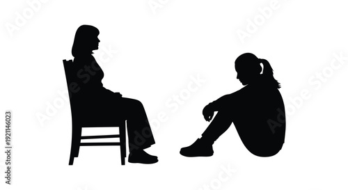 Two people in conversation one seated and one crouching silhouette