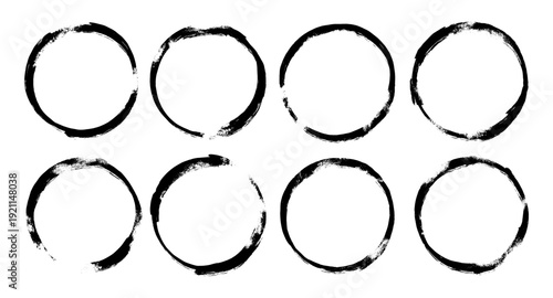 A collection of eight black spray paint circle frames featuring a raw grunge texture and authentic urban graffiti style, perfect for distressed borders and creative graphic design elements