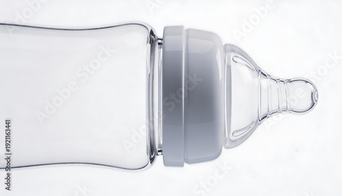 Clear baby bottle with teat and cap on white background