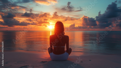 Young woman on seashore at sunset and looking at the sun. Woman on beach