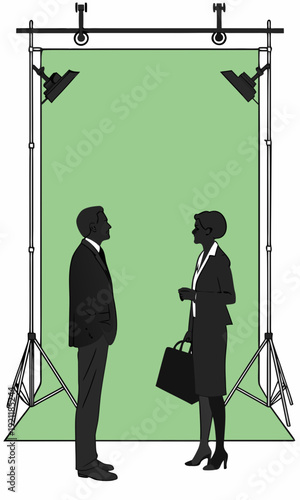 Two business people in silhouette stand before a green screen ready for a professional photoshoot or video shoot.