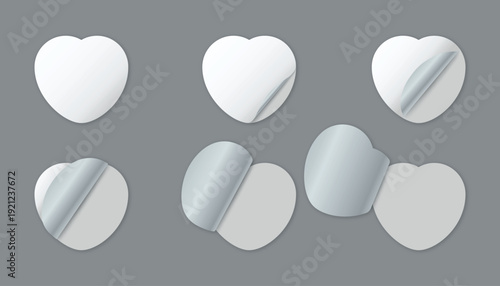 Six blank white heart-shaped stickers with peeling corners on gray background