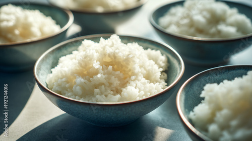 Several bowls of fluffy white rice are arranged on a table