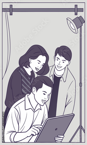 Three young adults reviewing content on a laptop in a studio setting.