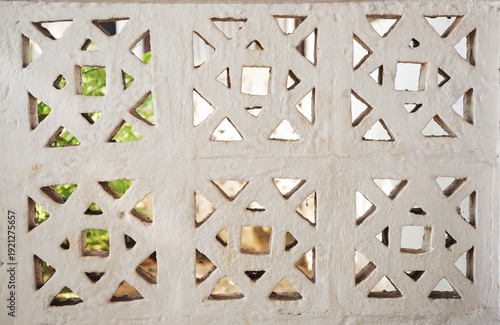 Obraz na plátne Light-colored breeze block wall with a geometric openwork pattern