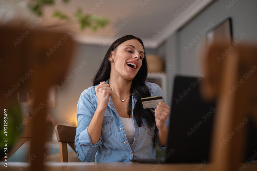 Obraz premium Woman celebrating online shopping success with credit card