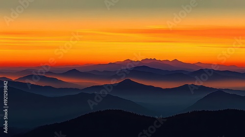 Layered mountain silhouettes and misty valleys beneath a vivid orange sunset sky, evoking calm and awe