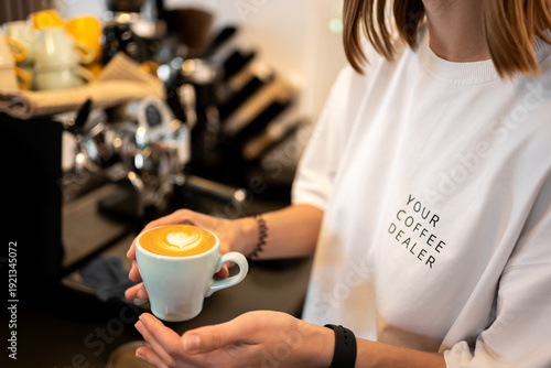Bilde på lerret Close-up of a female barista in a white sweatshirt that says YOUR COFFEE DEALER