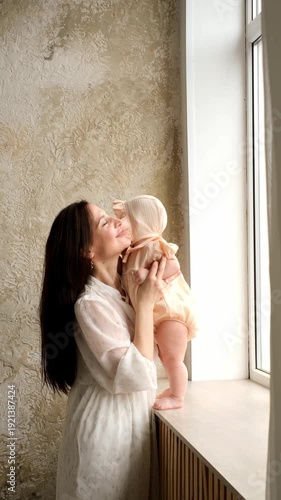 mother and baby, mother hugs and kisses her little daughter at home, mother's love and care, mother and child