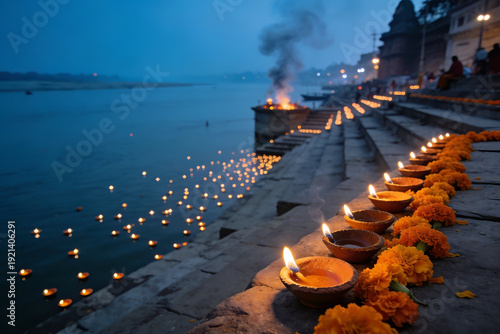 Clay oil lamps and marigolds on Varanasi ghat along Ganges River at dusk
