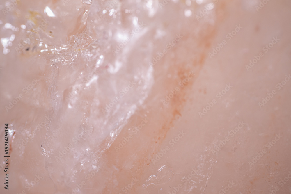Fototapeta premium Close-up view of translucent pink Himalayan salt crystal with visible texture and mineral inclusions, showcasing natural beauty and unique patterns in a neutral background