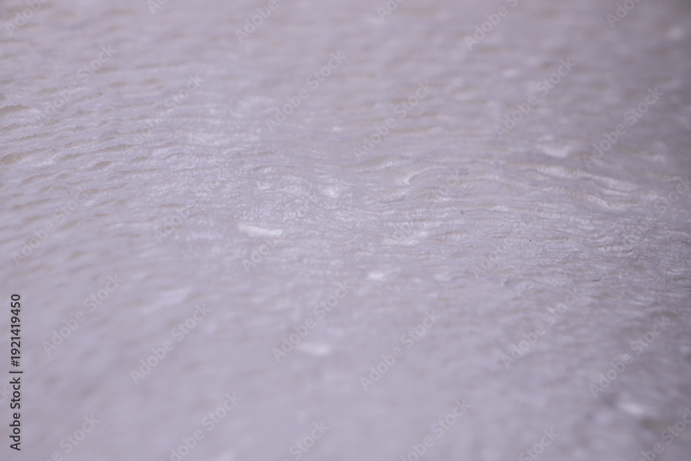 Obraz premium Close-up view of textured white surface with subtle ripples and variations, showcasing a smooth, soft appearance suitable for backgrounds or design elements