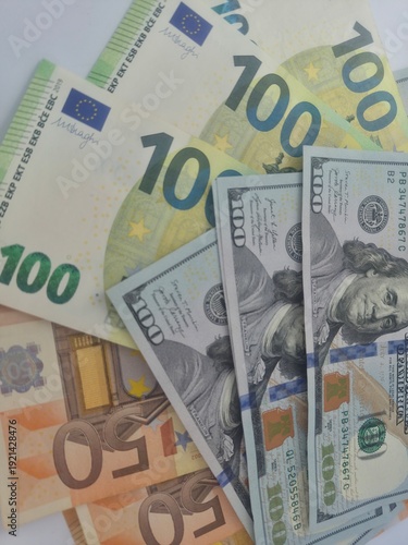 Fotografi Close-up shot of Euro and US Dollar banknotes scattered on a flat surface, symbolizing global finance and currency exchange