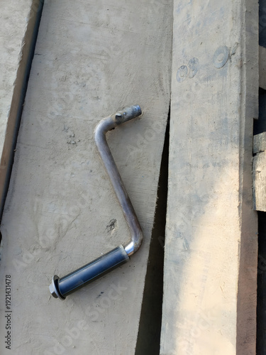 Metal Crank Handle on Rough Concrete Surface, Industrial Tool Detail